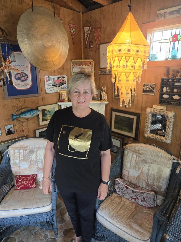 Deb Stokes shows off the interior of her she shed. Her T-shirt sports Jim's business logo.